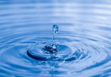 Wasser Bild von einem Wassertropfen der in blaues Wasser fällt.
