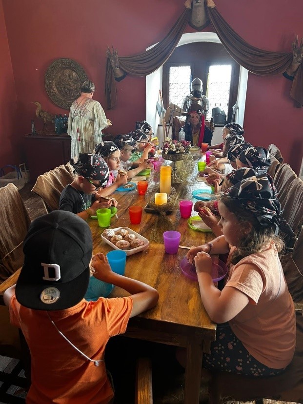 Schulanfänger als Piraten verkleidet bei Piratenessen an einer langen Tafel