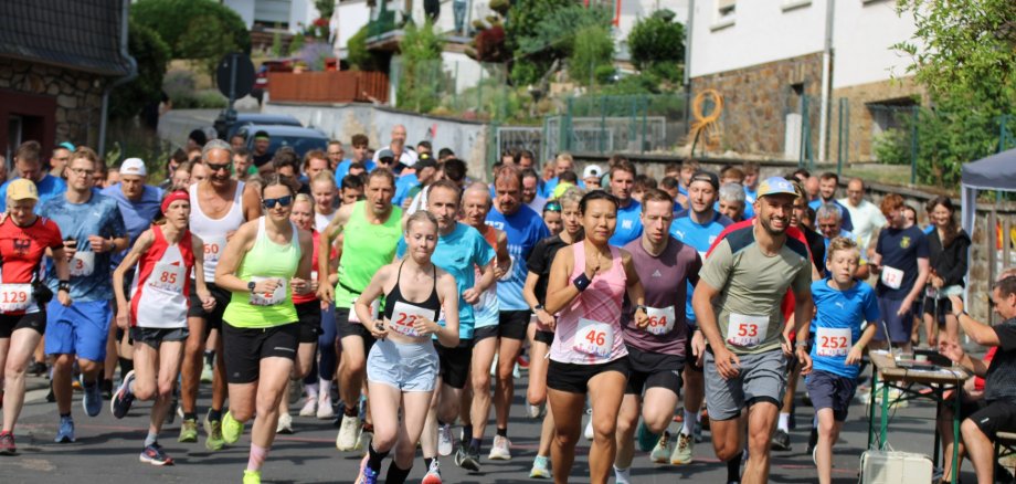 Start 9. Dorflauf Kraftsolms Teilnehmerinnen und Teilnehmer starten gemeinsam bei einem Volkslauf in einer Ortschaft und laufen motiviert auf der Straße los.